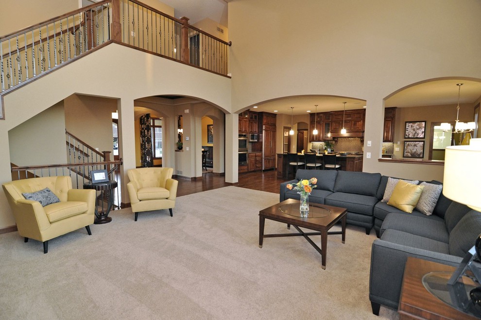 На фото: большая открытая гостиная комната в стиле кантри с ковровым покрытием, стандартным камином и фасадом камина из камня с