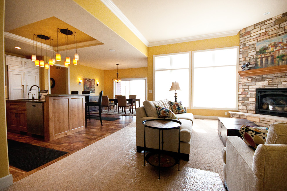 Mittelgroßes, Repräsentatives, Abgetrenntes Uriges Wohnzimmer mit gelber Wandfarbe, Teppichboden, Eckkamin, Kaminumrandung aus Stein, buntem Boden und eingelassener Decke in Sonstige