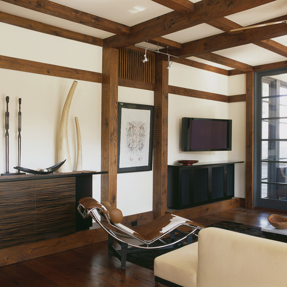 This is an example of a world-inspired living room in DC Metro with dark hardwood flooring and a wall mounted tv.