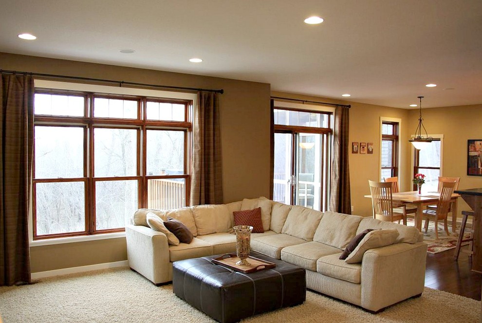 Mittelgroßes, Offenes Uriges Wohnzimmer mit beiger Wandfarbe, Teppichboden, Kamin, Kaminumrandung aus Stein und TV-Wand in Minneapolis