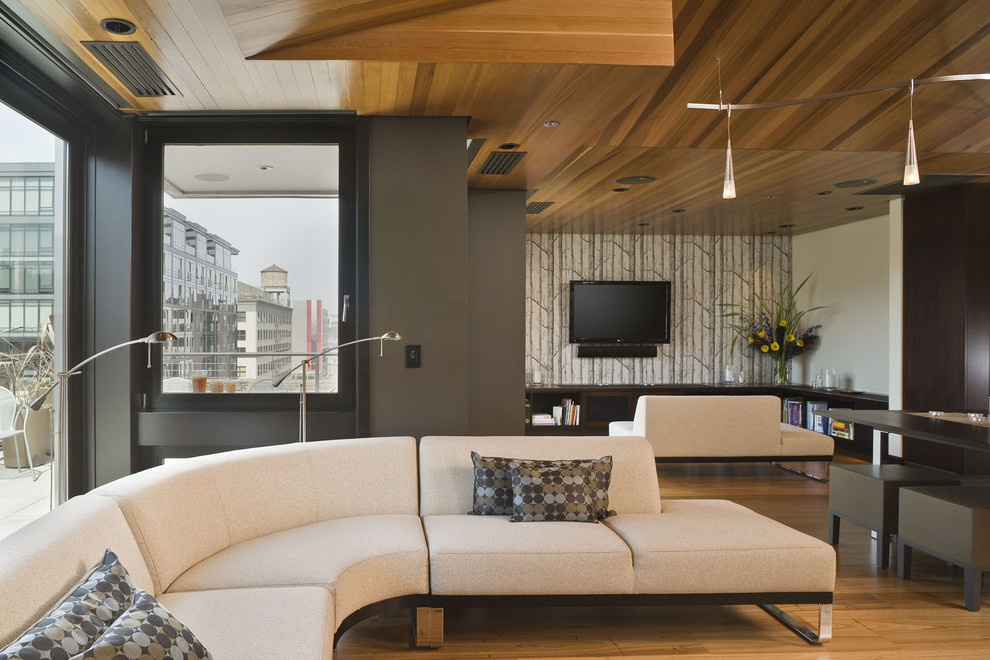 Exempel på ett modernt vardagsrum, med grå väggar och en väggmonterad TV
