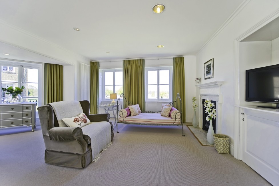 На фото: гостиная комната в современном стиле с ковровым покрытием, стандартным камином и фасадом камина из камня