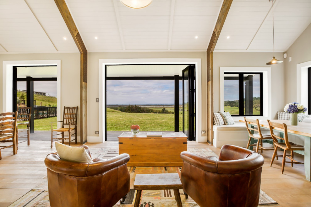 Immagine di un soggiorno country aperto con pareti beige, pavimento in legno massello medio, pavimento marrone e soffitto a volta