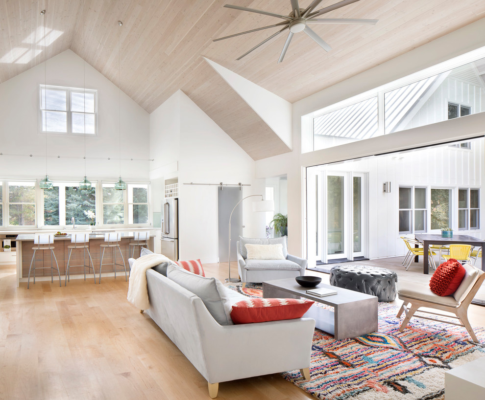 Imagen de salón abierto campestre de tamaño medio con paredes blancas y suelo de madera clara