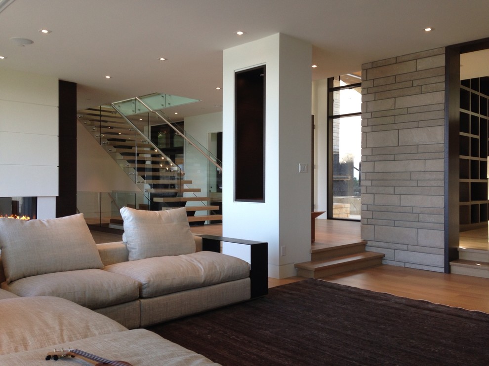 Ejemplo de salón abierto actual de tamaño medio con paredes blancas, suelo de madera clara y suelo marrón