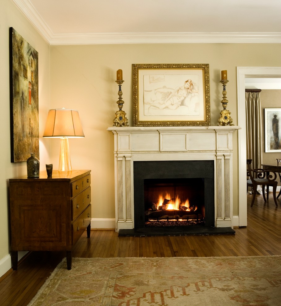 チャールストンにある高級な中くらいなヴィクトリアン調のおしゃれなリビング (ベージュの壁、無垢フローリング、標準型暖炉、木材の暖炉まわり、テレビなし) の写真