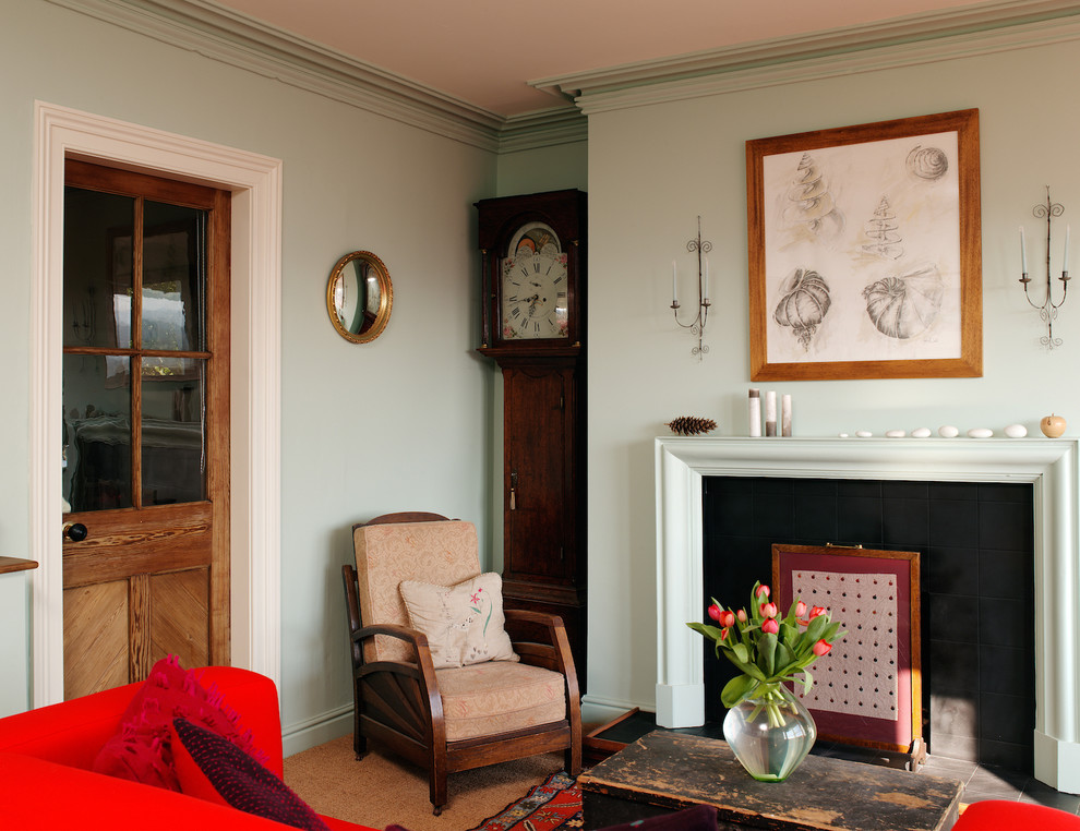 Klassisches Wohnzimmer mit blauer Wandfarbe, Teppichboden und Kaminumrandung aus Holz in Sonstige