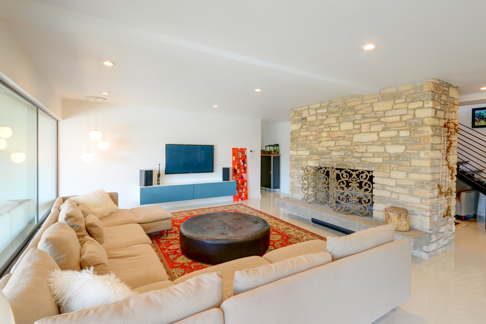 オースティンにある広いトランジショナルスタイルのおしゃれなLDK (白い壁、コンクリートの床、標準型暖炉、石材の暖炉まわり、壁掛け型テレビ) の写真