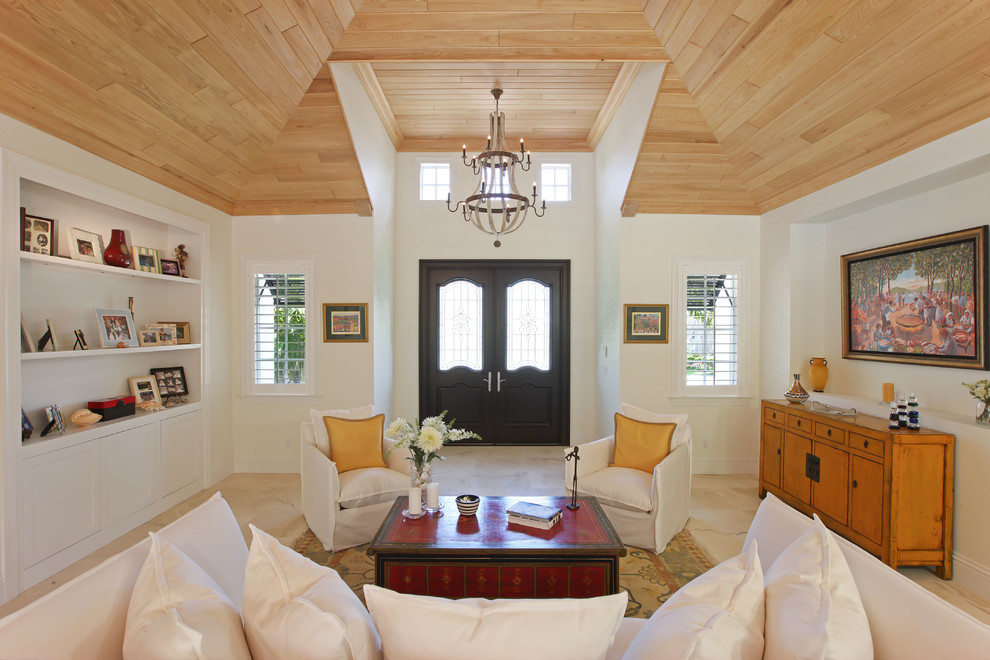 Imagen de salón para visitas abierto tropical grande sin chimenea y televisor con paredes blancas y suelo de travertino