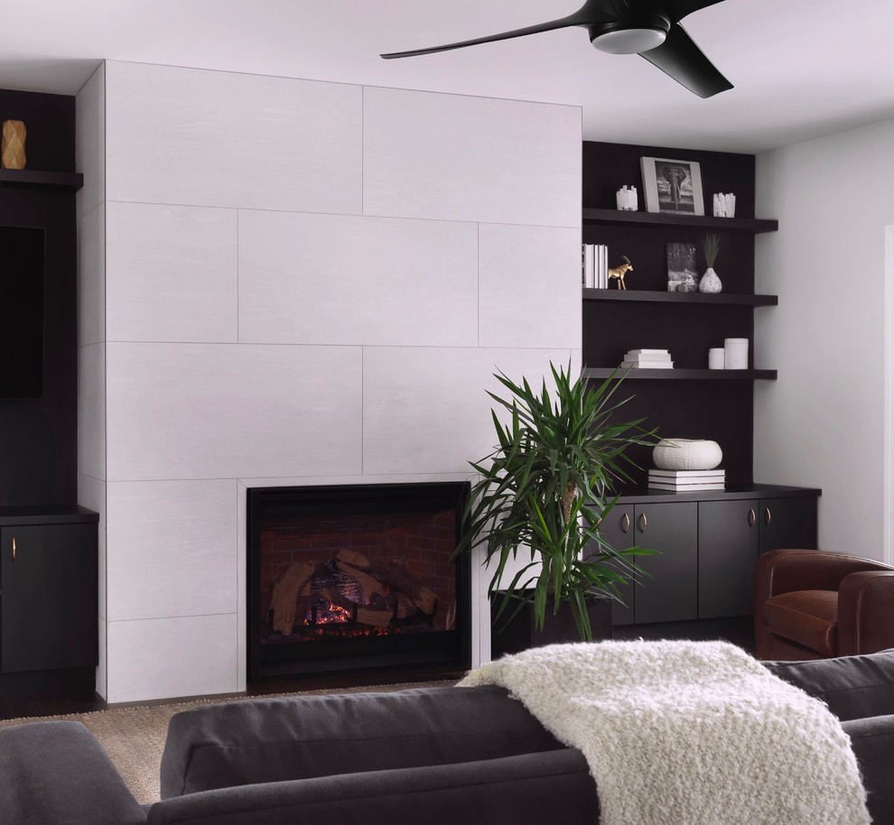 Источник вдохновения для домашнего уюта: открытая гостиная комната среднего размера в стиле неоклассика (современная классика) с черными стенами, полом из керамической плитки, стандартным камином, фасадом камина из плитки, скрытым телевизором и коричневым полом