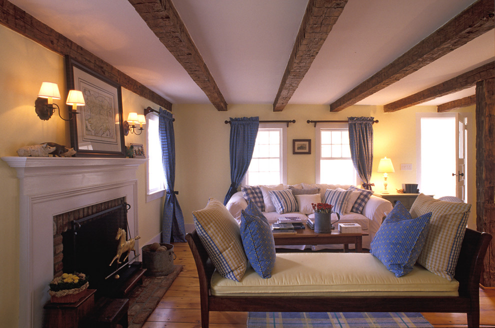 Пример оригинального дизайна: гостиная комната в стиле кантри с бежевыми стенами, стандартным камином, фасадом камина из кирпича и красивыми шторами