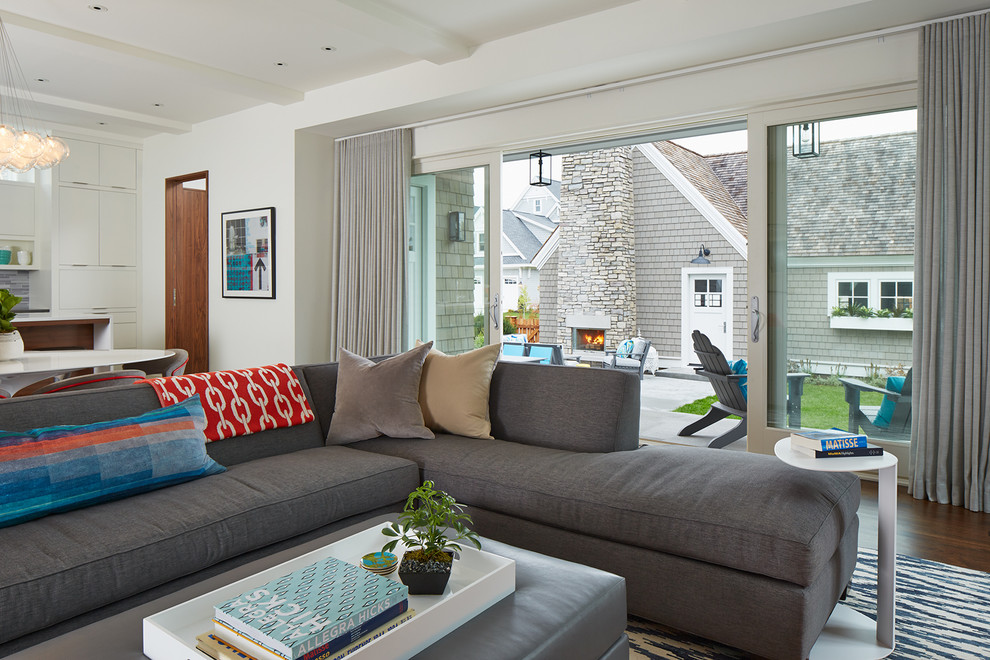 Стильный дизайн: открытая гостиная комната в современном стиле с белыми стенами, паркетным полом среднего тона, стандартным камином и фасадом камина из камня - последний тренд