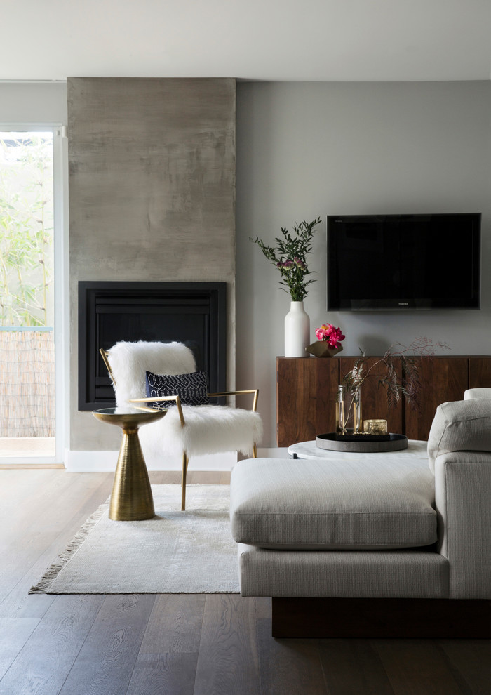 Idee per un soggiorno design di medie dimensioni con pareti grigie, parquet scuro, camino classico, TV a parete e pavimento marrone