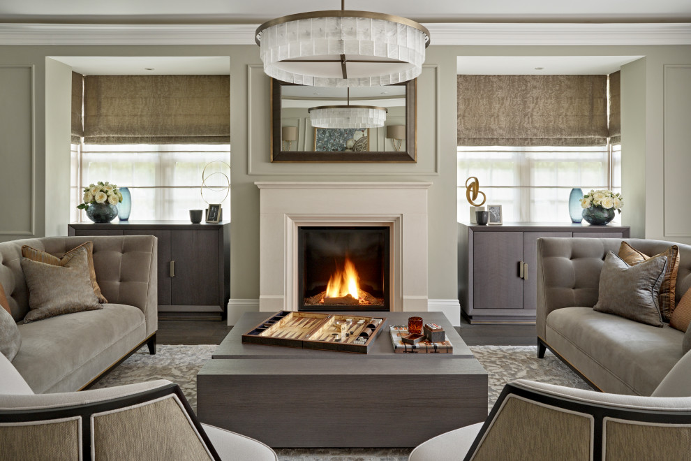 Cette photo montre un grand salon tendance fermé avec une cheminée standard, un manteau de cheminée en pierre, un mur gris, parquet foncé, un sol marron et du lambris.