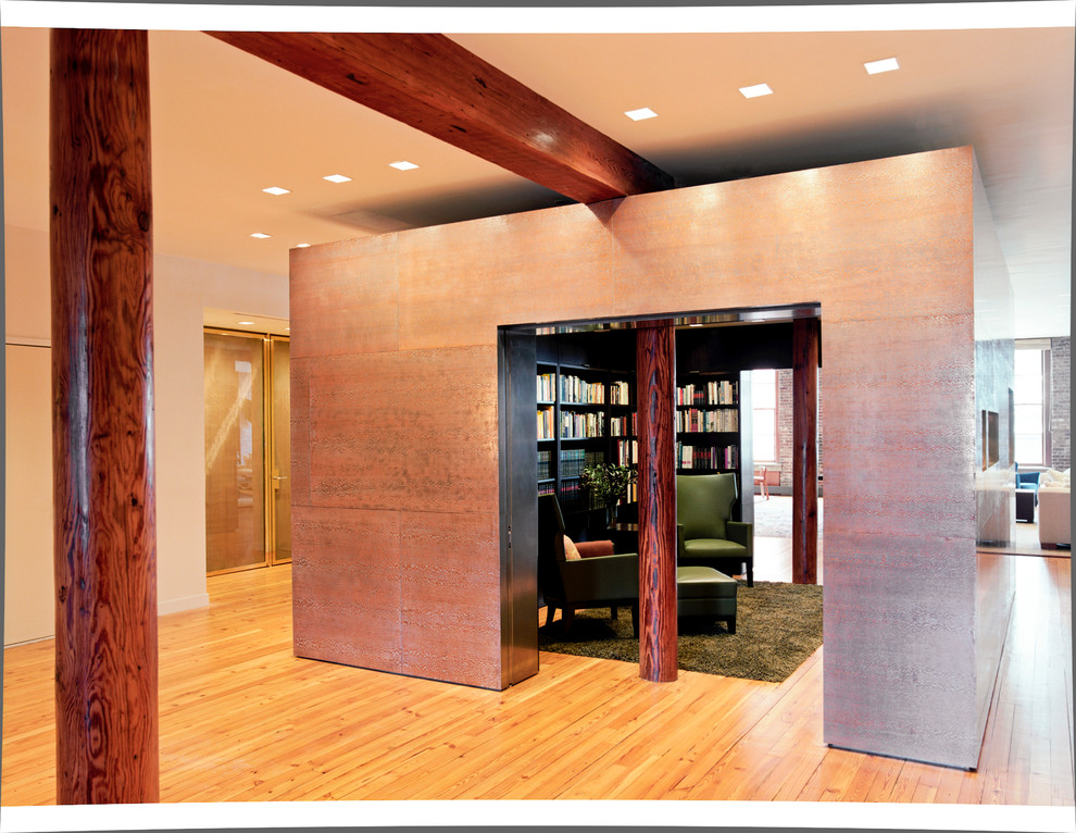 Imagen de biblioteca en casa cerrada actual de tamaño medio sin chimenea y televisor con paredes negras y suelo de madera clara