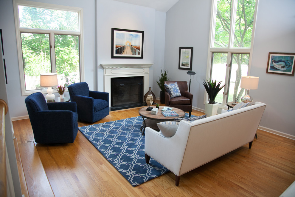 Идея дизайна: парадная, изолированная гостиная комната среднего размера в стиле неоклассика (современная классика) с синими стенами, светлым паркетным полом, стандартным камином и фасадом камина из штукатурки без телевизора