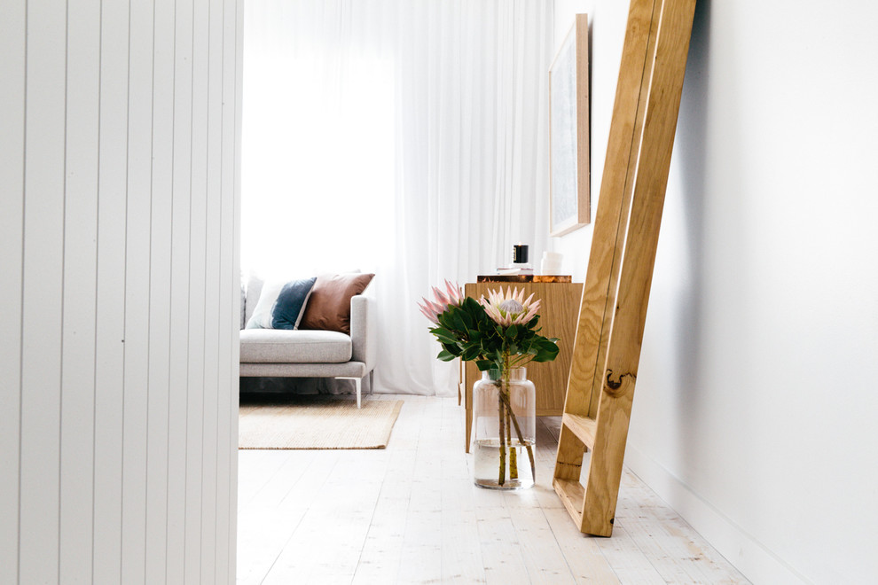 Modelo de salón escandinavo de tamaño medio con paredes blancas y suelo de madera pintada