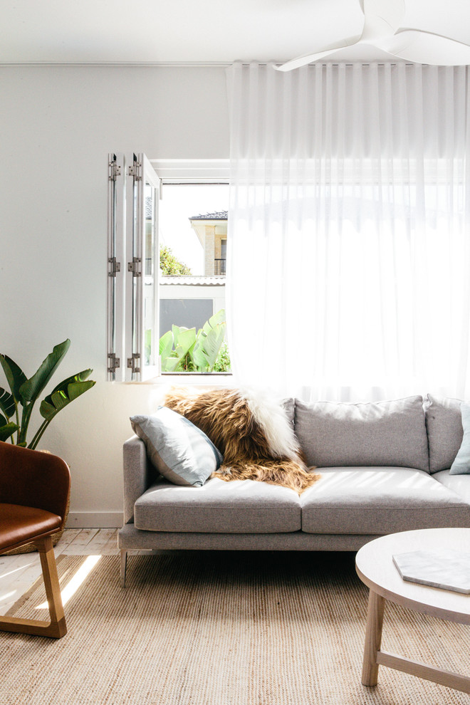 Mittelgroßes Nordisches Wohnzimmer mit weißer Wandfarbe und gebeiztem Holzboden in Sydney