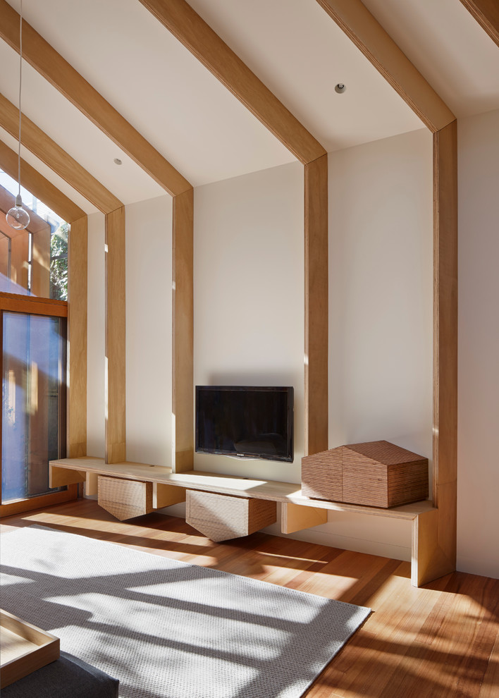 Immagine di un soggiorno design di medie dimensioni e aperto con pareti bianche, parquet chiaro e TV a parete