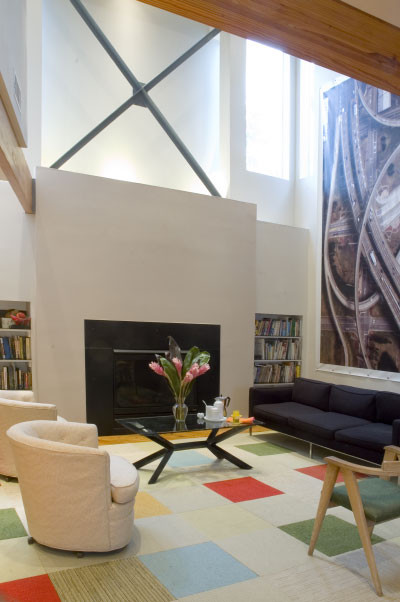 Foto de salón tipo loft moderno extra grande con paredes blancas, suelo de madera clara y marco de chimenea de piedra