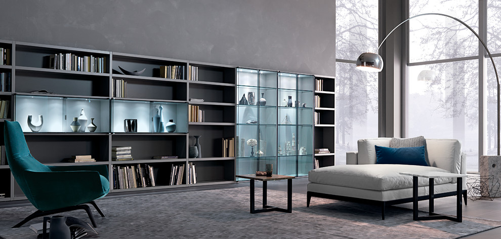 Modelo de biblioteca en casa cerrada minimalista grande sin chimenea con paredes grises, suelo de madera oscura y pared multimedia