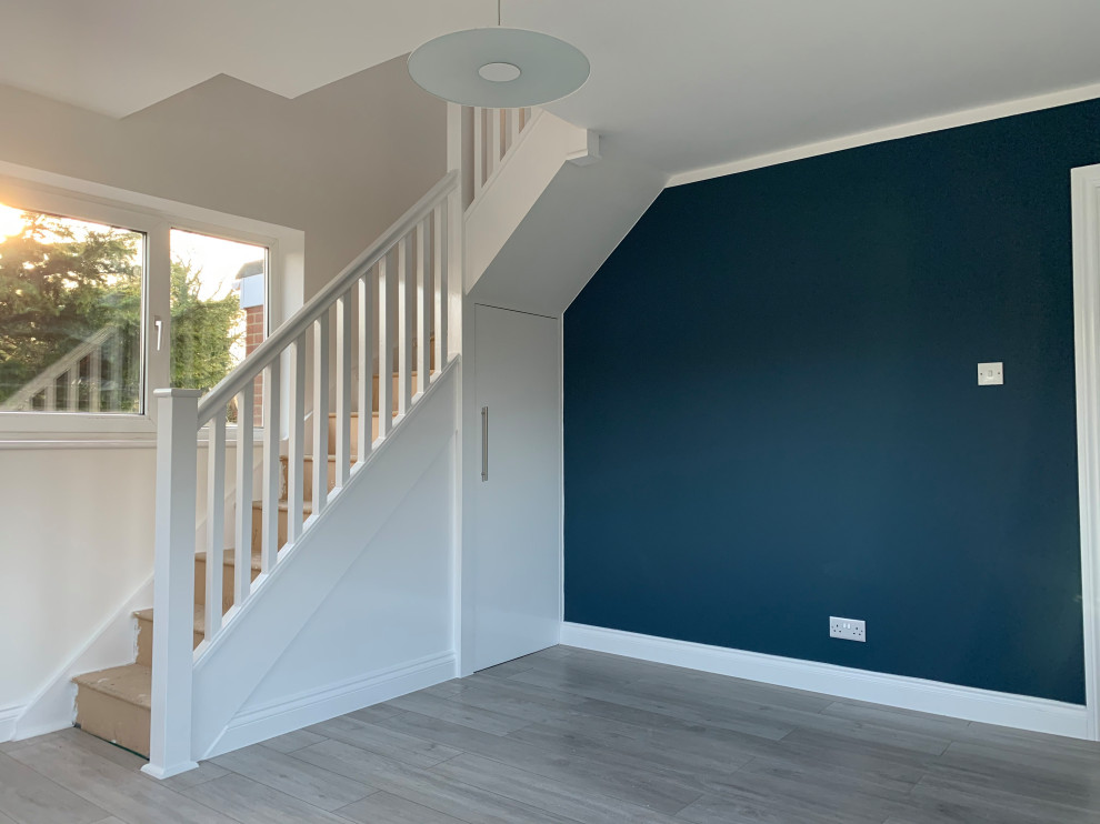Photo of a medium sized modern formal enclosed living room in Buckinghamshire with blue walls, laminate floors, no fireplace, no tv and multi-coloured floors.