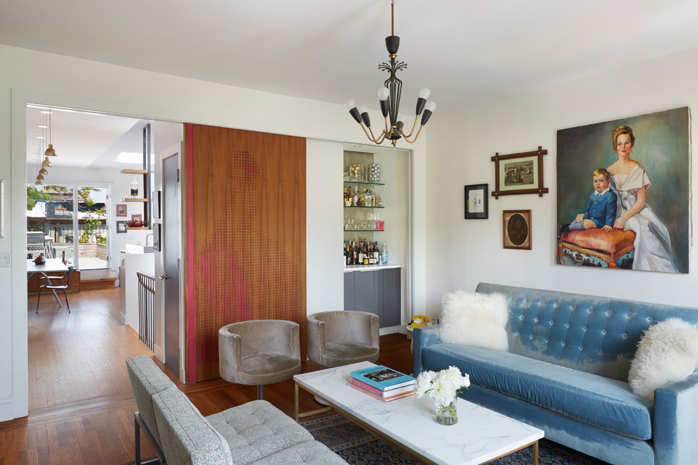 Imagen de salón con barra de bar bohemio con paredes blancas y suelo de madera en tonos medios