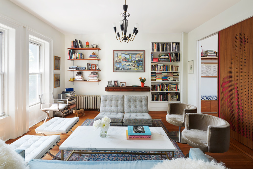 Idee per un soggiorno boho chic chiuso con libreria, pareti bianche e pavimento in legno massello medio