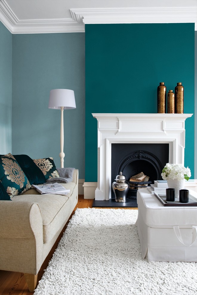 ダブリンにある中くらいなトランジショナルスタイルのおしゃれなリビング (青い壁、無垢フローリング、標準型暖炉、テレビなし) の写真