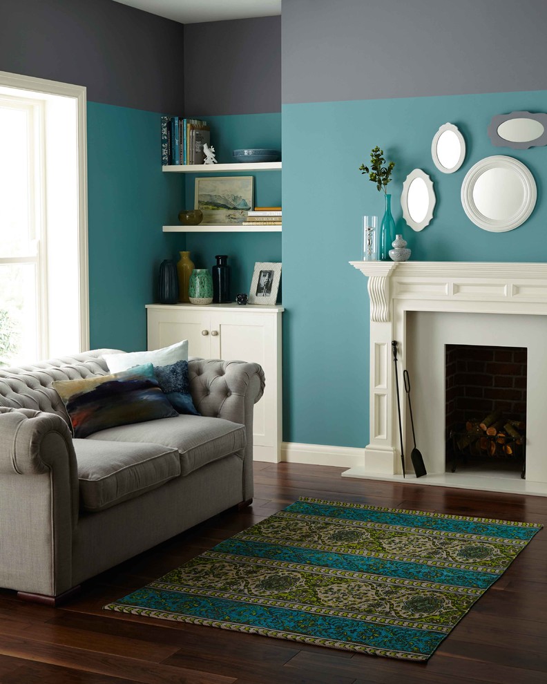 Mittelgroßes, Abgetrenntes Modernes Wohnzimmer mit blauer Wandfarbe, braunem Holzboden, Kamin und verputzter Kaminumrandung in Dublin