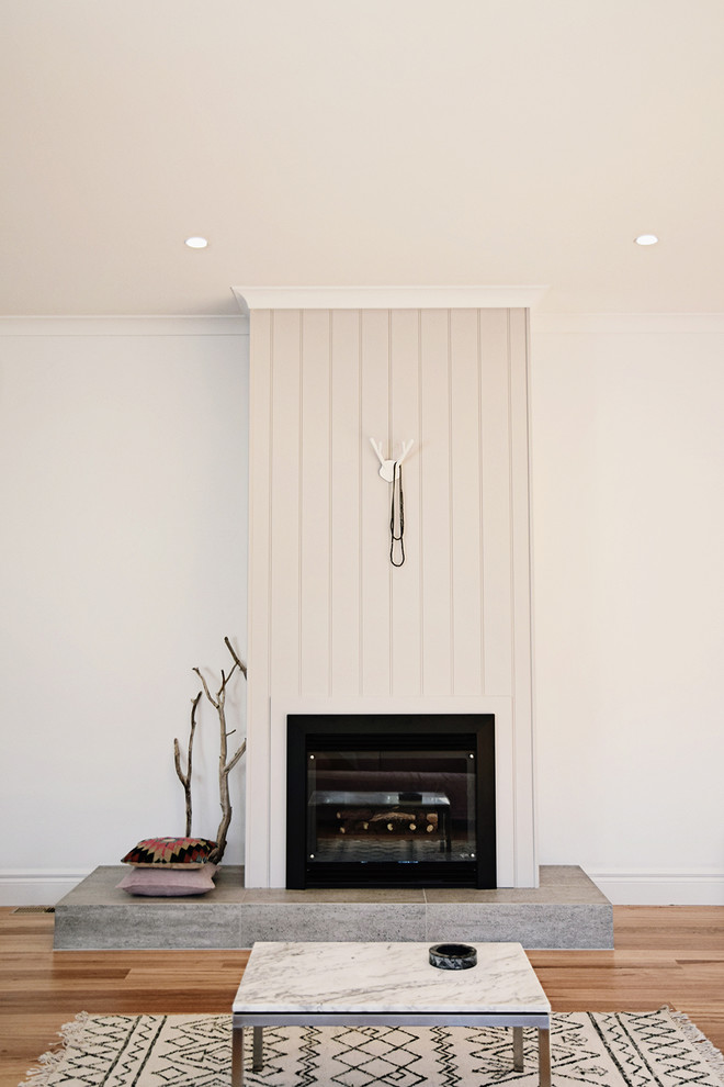 Medium sized scandi living room in Melbourne with a standard fireplace, white walls and medium hardwood flooring.