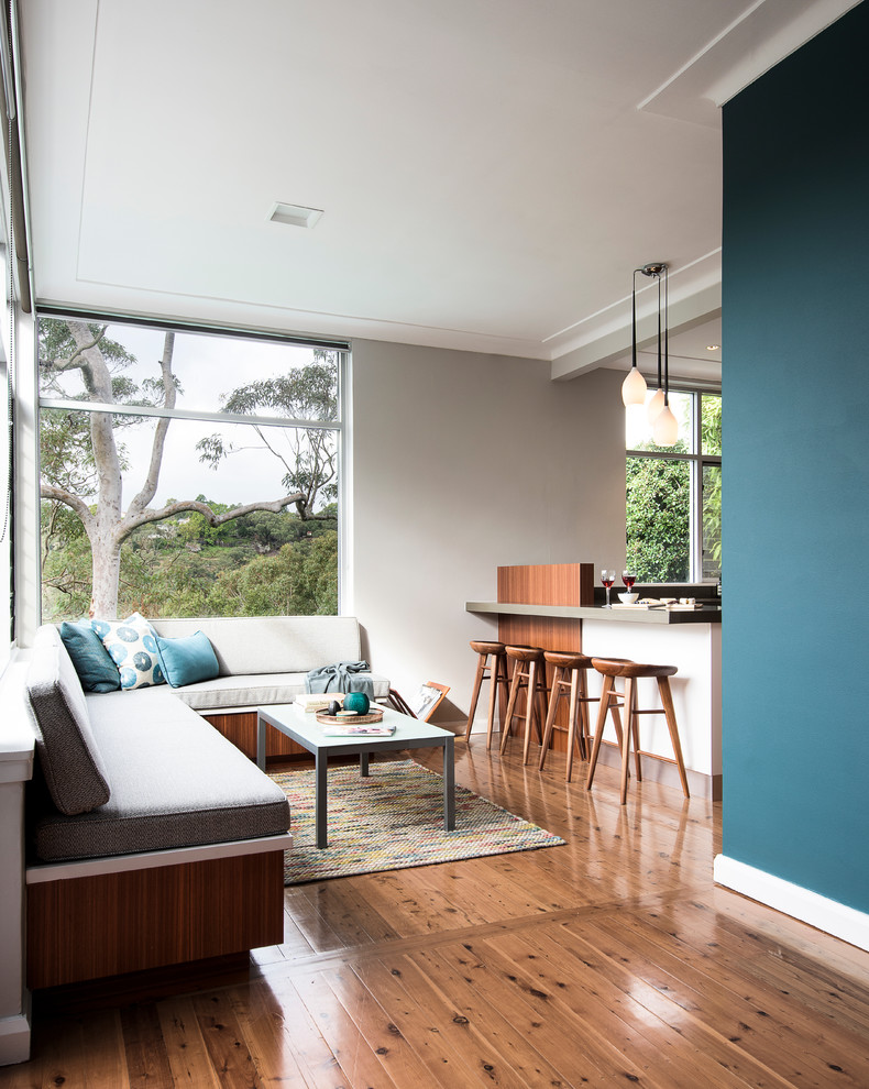 Idee per un soggiorno contemporaneo con pareti blu e pavimento in legno massello medio