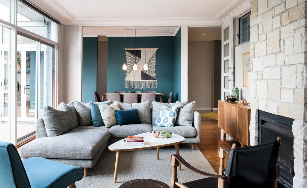 Offenes Klassisches Wohnzimmer mit grauer Wandfarbe, hellem Holzboden, Kamin und Kaminumrandung aus Stein in Sydney