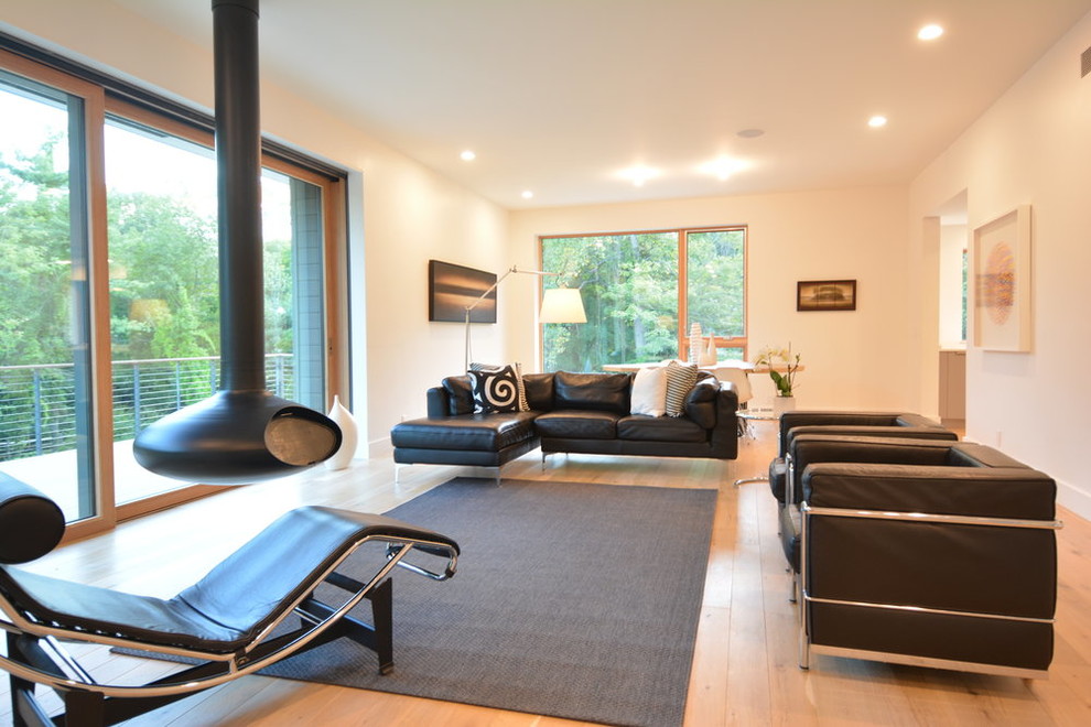 Mittelgroßes, Abgetrenntes Modernes Wohnzimmer mit beiger Wandfarbe, hellem Holzboden, Hängekamin und beigem Boden in New York