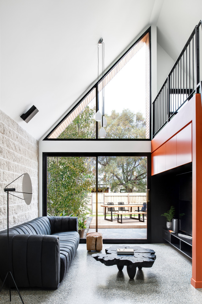 This is an example of a contemporary living room in Melbourne with white walls, concrete flooring and grey floors.