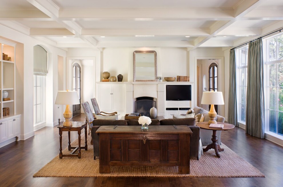 Inspiration for a traditional living room in Austin with white walls, dark hardwood flooring, a standard fireplace, a built-in media unit and brown floors.