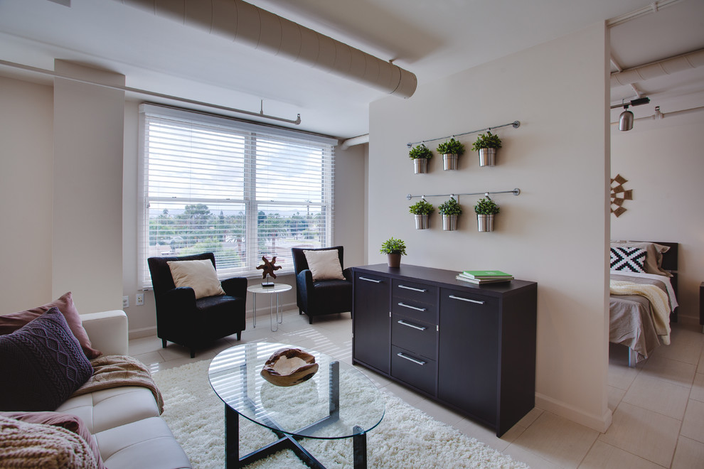 Idee per un piccolo soggiorno design aperto con pareti beige e pavimento in gres porcellanato