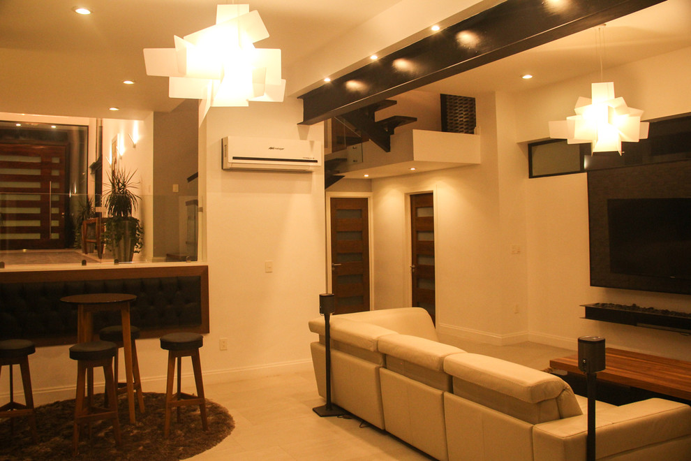 На фото: огромная открытая гостиная комната в современном стиле с домашним баром, белыми стенами, полом из керамической плитки, подвесным камином, фасадом камина из металла и телевизором на стене с