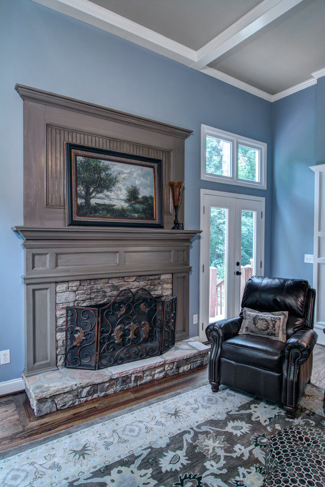 Пример оригинального дизайна: гостиная комната среднего размера в классическом стиле с синими стенами, паркетным полом среднего тона, стандартным камином и фасадом камина из дерева