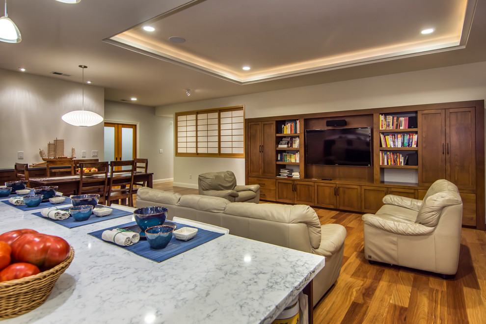 Foto di un soggiorno tradizionale aperto con pareti beige, pavimento in legno massello medio e TV a parete