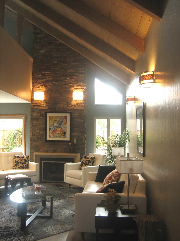 Идея дизайна: двухуровневая гостиная комната среднего размера в стиле рустика с бежевыми стенами, полом из керамогранита, стандартным камином, фасадом камина из камня и телевизором на стене
