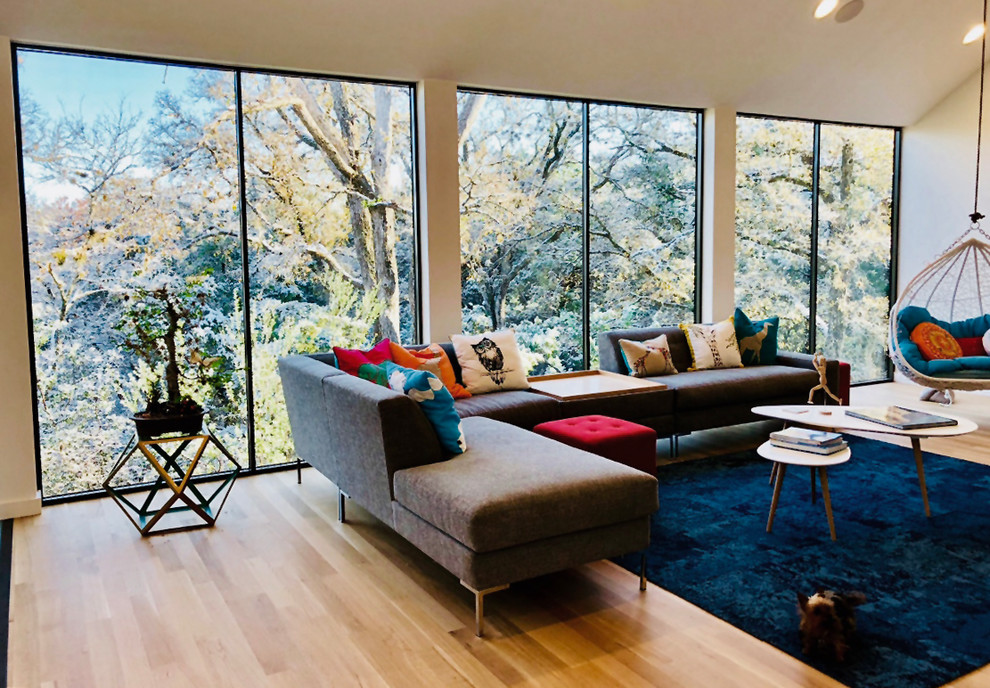 Mittelgroßes, Offenes Modernes Wohnzimmer mit weißer Wandfarbe, braunem Holzboden und beigem Boden in Austin