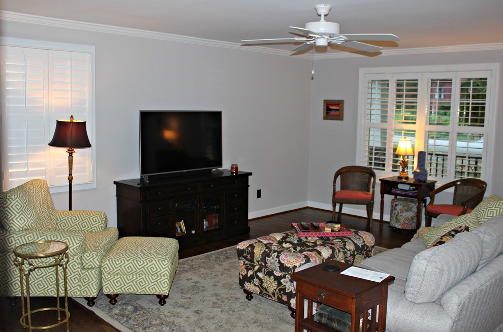 Foto di un soggiorno american style chiuso con pareti grigie, parquet scuro, camino classico e TV autoportante