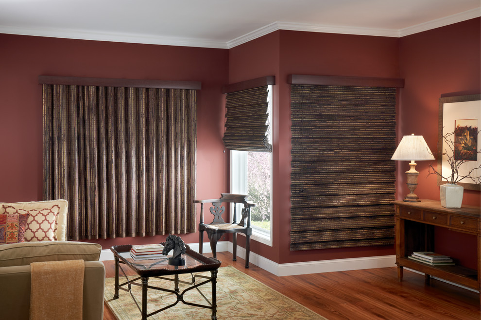 Réalisation d'un salon bohème de taille moyenne avec un mur rouge et un sol en bois brun.