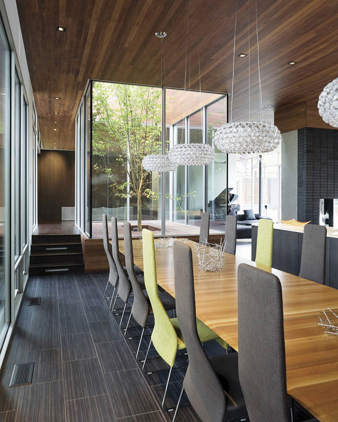 Aménagement d'une très grande salle à manger moderne avec un mur gris, moquette, une cheminée standard, un manteau de cheminée en brique et un sol marron.