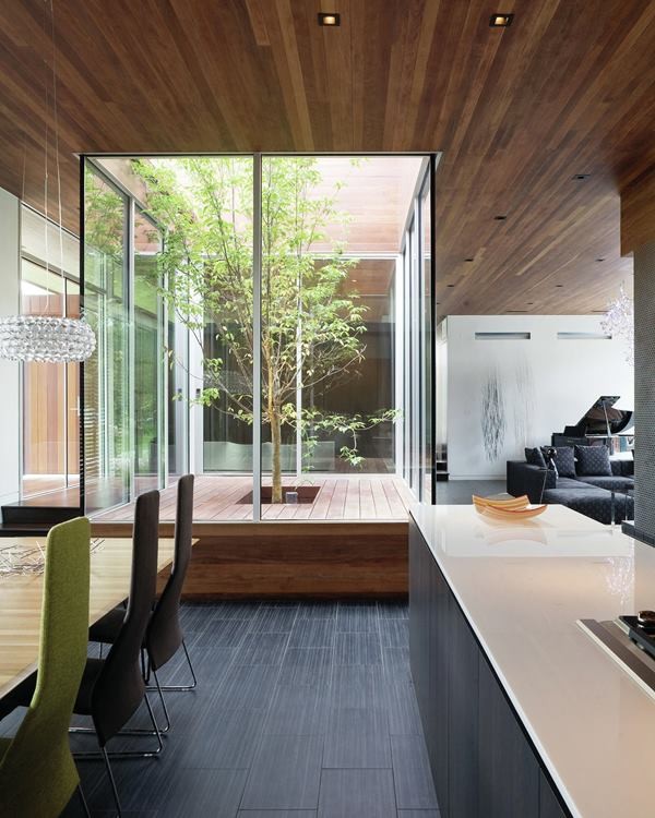 Cette image montre un très grand salon minimaliste ouvert avec un mur gris, moquette, une cheminée standard, un manteau de cheminée en brique et un téléviseur indépendant.