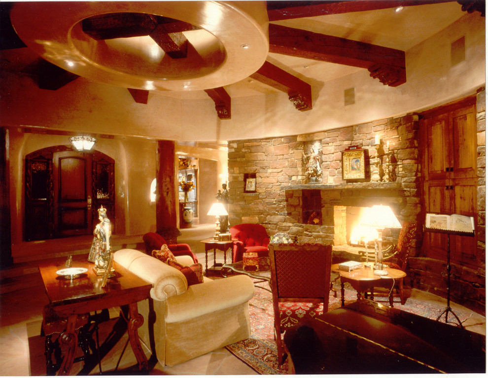 Exemple d'un grand salon sud-ouest américain fermé avec une salle de musique, un mur beige, un sol en calcaire, une cheminée standard, un manteau de cheminée en pierre et un téléviseur dissimulé.