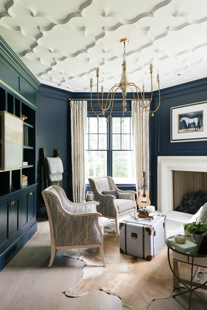 アトランタにある高級な広いトランジショナルスタイルのおしゃれなリビング (青い壁、淡色無垢フローリング、標準型暖炉、漆喰の暖炉まわり、テレビなし、茶色い床) の写真