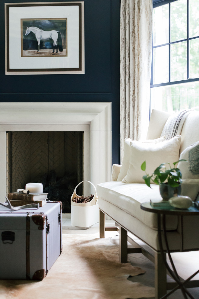 Idée de décoration pour un grand salon tradition fermé avec une salle de réception, une cheminée standard, un manteau de cheminée en plâtre, aucun téléviseur, un mur bleu, parquet clair et un sol beige.