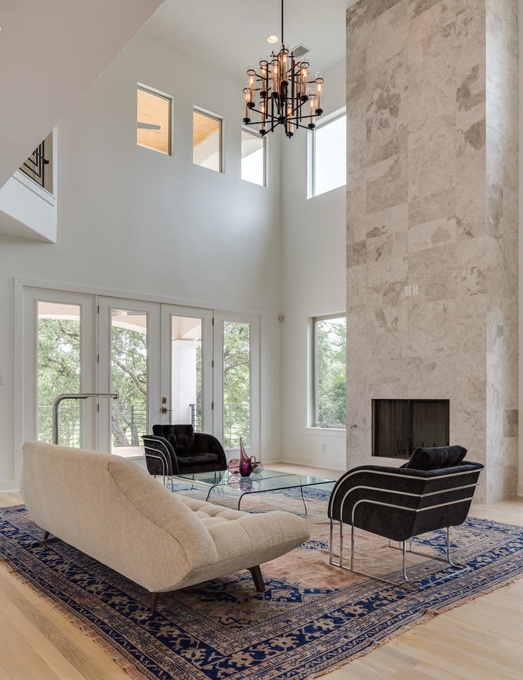 Diseño de salón abierto actual de tamaño medio sin televisor con paredes blancas, suelo de madera clara, todas las chimeneas, marco de chimenea de piedra y suelo marrón